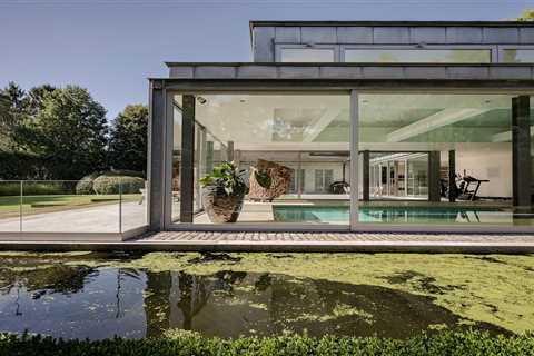 A  Contemporary Villa in Belgium Comes Complete With a Landscape Pond and Showroom Garage